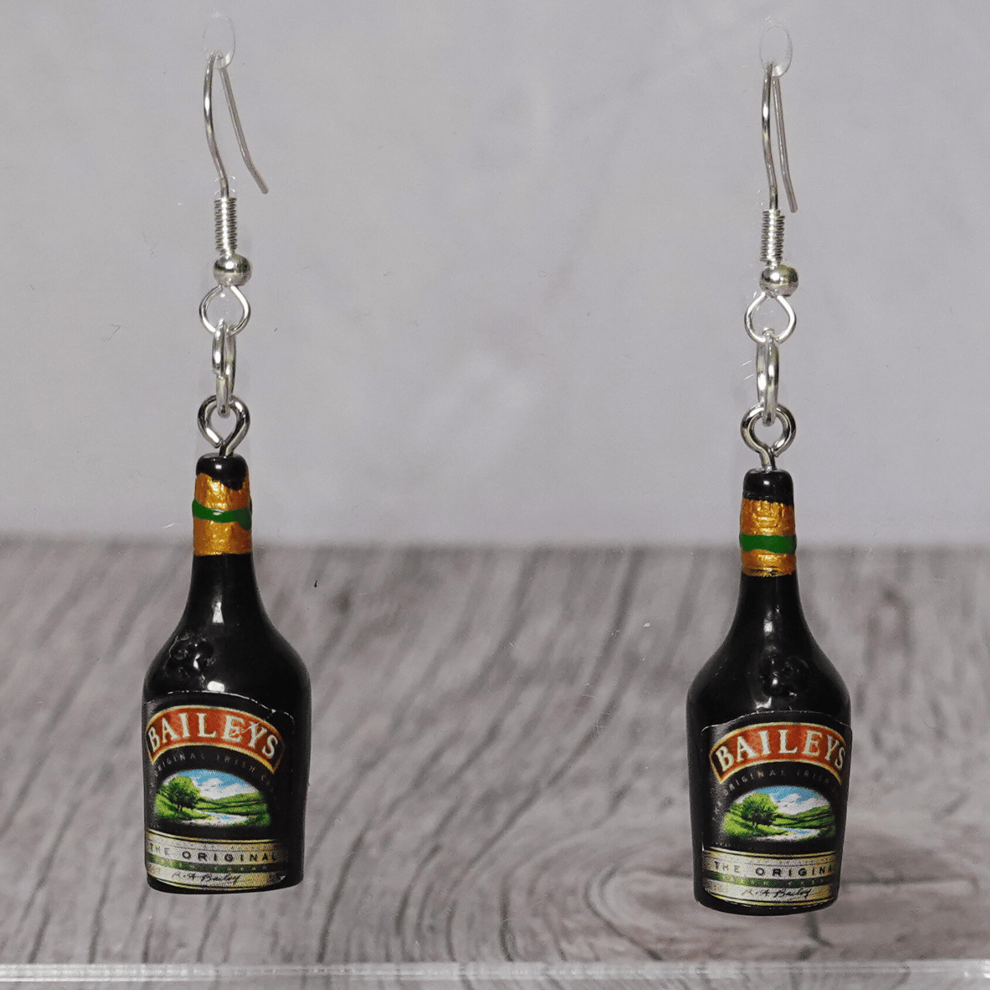 Mini Irish cream liqueur bottle shaped dangle earrings with dark bottle design and silver hooks.