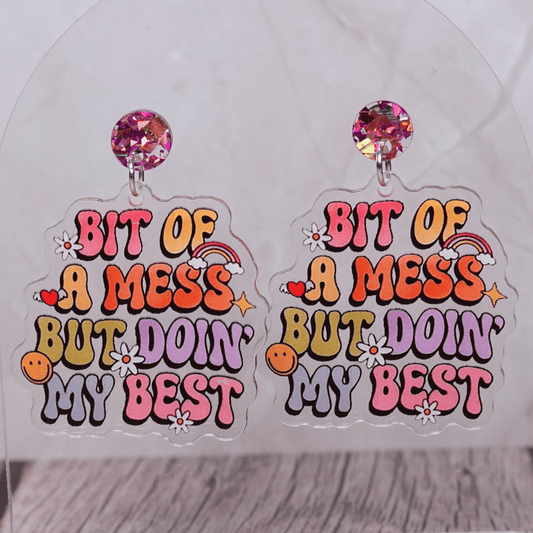 Colorful novelty dangle earrings with text “bit of a mess but doin’ my best”
