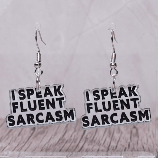 Black and white novelty earrings reading “I speak fluent sarcasm”