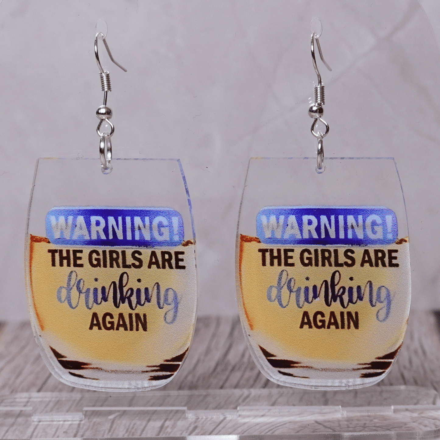 Wine glass dangle earrings with text “warning the girls are drinking again”