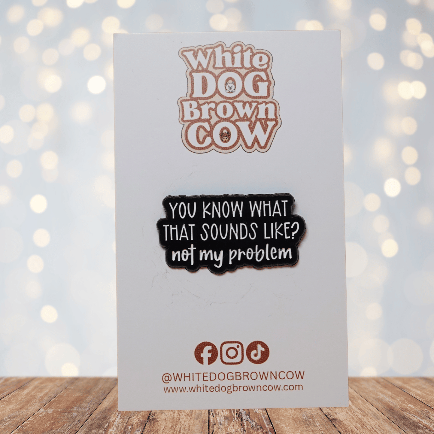 Black and white enamel pin reading “You Know What That Sounds Like? Not My Problem” in bold lettering, funny sarcastic office humor lapel pin.