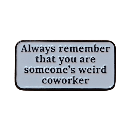 Rectangular enamel pin with the quote “Always remember that you are someone’s weird coworker” in black text on a white background.