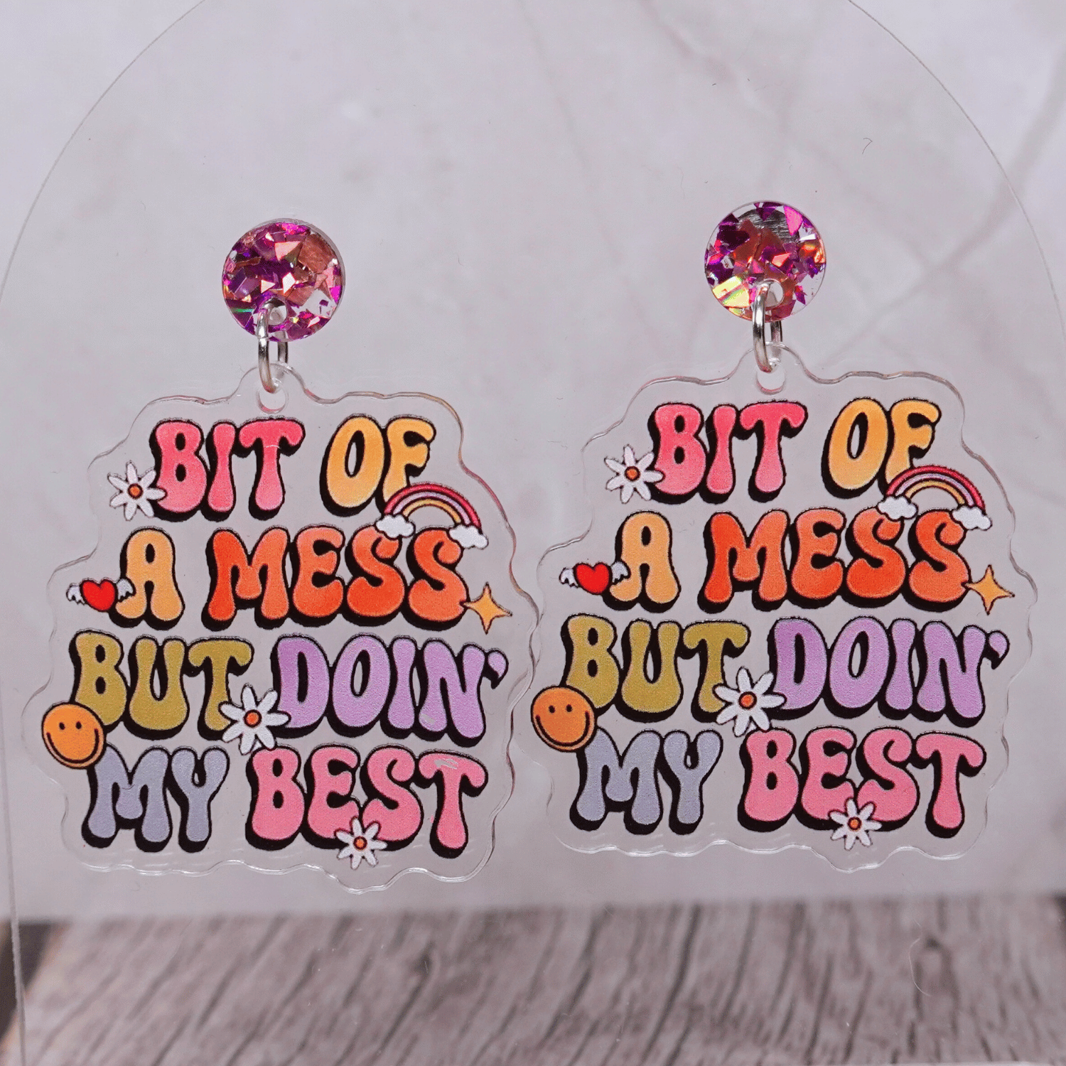 Colorful novelty dangle earrings with text “bit of a mess but doin’ my best”