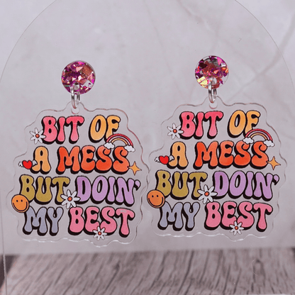 Colorful novelty dangle earrings with text “bit of a mess but doin’ my best”