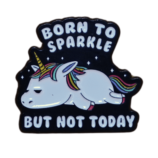 Unicorn enamel pin with rainbow mane and the quote “Born to sparkle but not today” on a dark background.