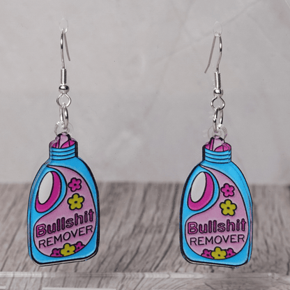 Colorful novelty dangle earrings shaped like a detergent bottle labeled “Bullsh*t remover”