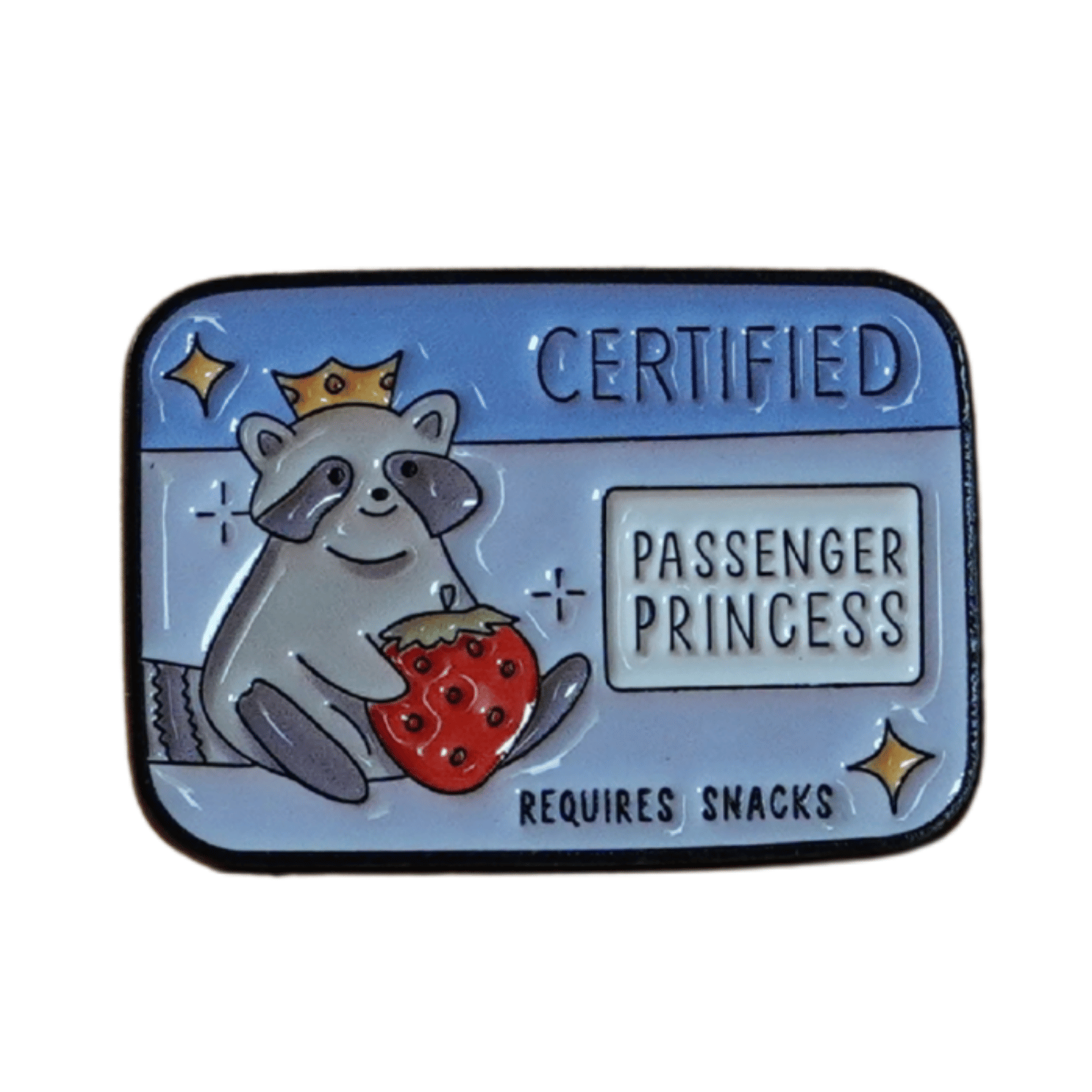 Raccoon enamel pin wearing a crown, holding a strawberry, with text “Certified Passenger Princess – Requires Snacks.”
