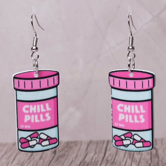 Pink novelty dangle earrings shaped like a “Chill Pills” bottle