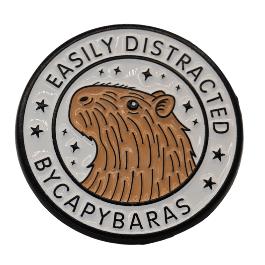 Cute enamel pin with capybara illustration and text “easily distracted by capybaras,” funny animal novelty pin