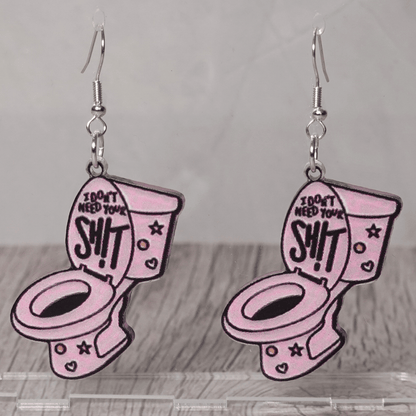 Pink novelty dangle earrings shaped like a toilet with text “I don’t need your sh*t”