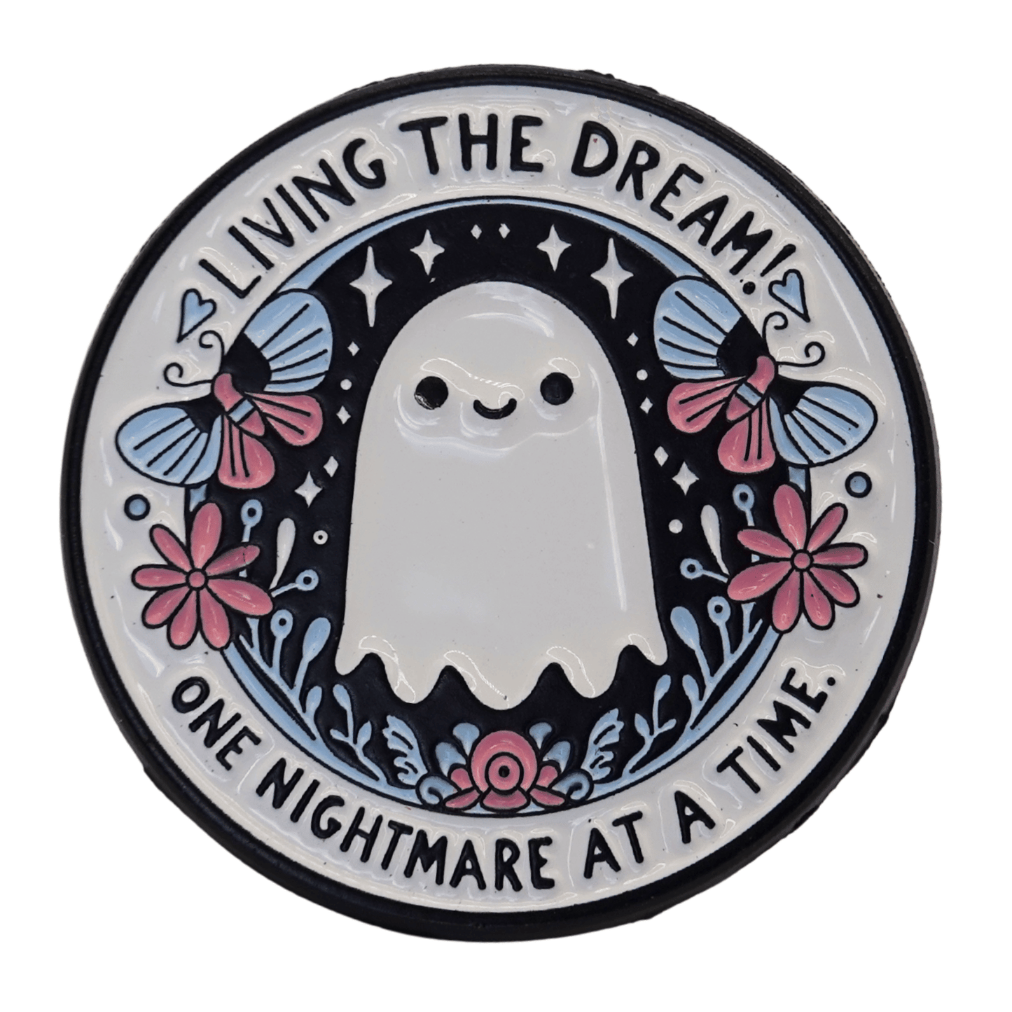Cute ghost enamel pin with flowers and text “living the dream one nightmare at a time,” funny sarcastic spooky pin