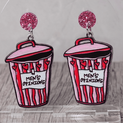 Acrylic dangle earrings shaped like a pink and red trash can labeled “Men’s Opinions”