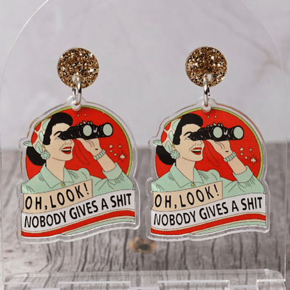 Retro style novelty dangle earrings showing a woman with binoculars and the phrase “Oh look nobody gives a sh*t”