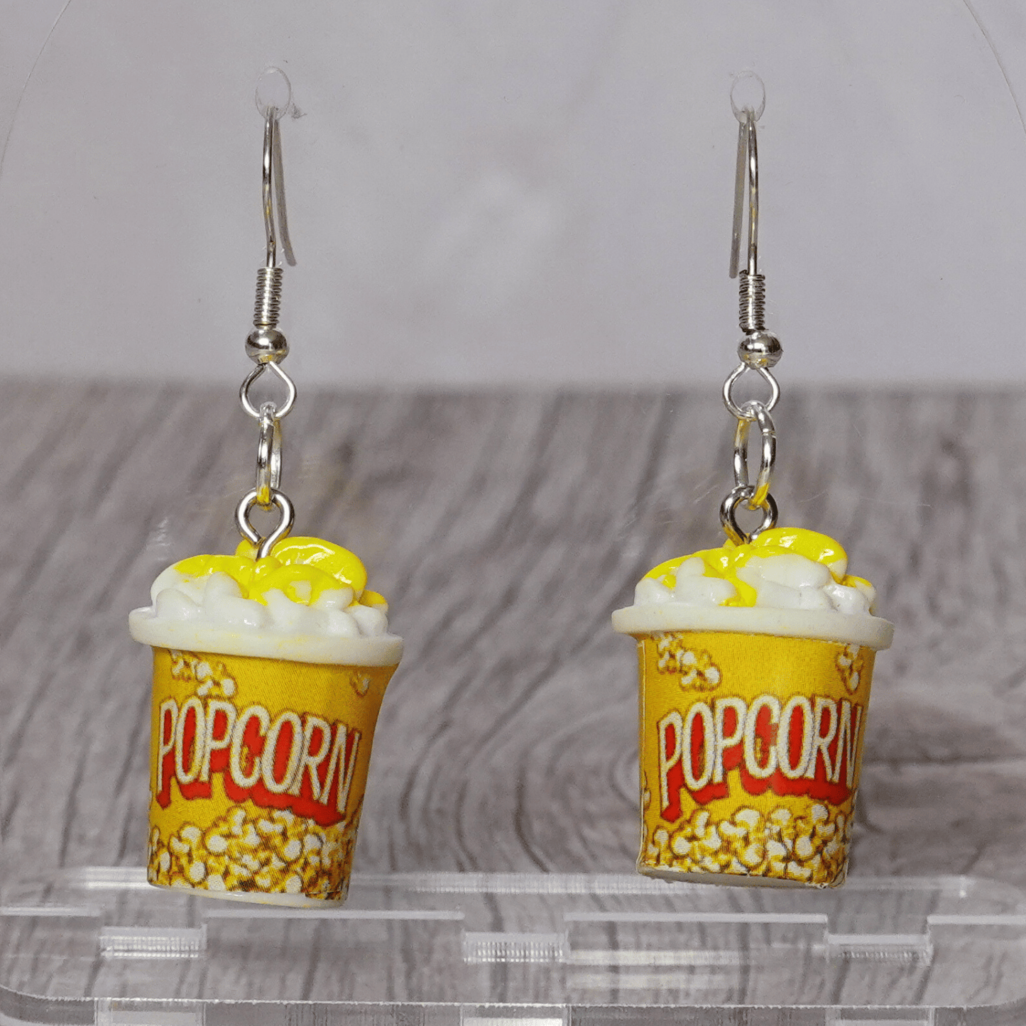Yellow popcorn bucket shaped dangle earrings filled with popcorn and silver hooks.