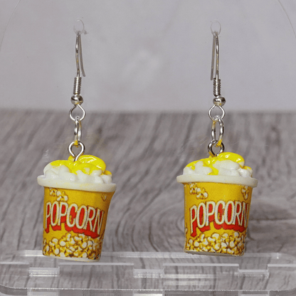 Yellow popcorn bucket shaped dangle earrings filled with popcorn and silver hooks.