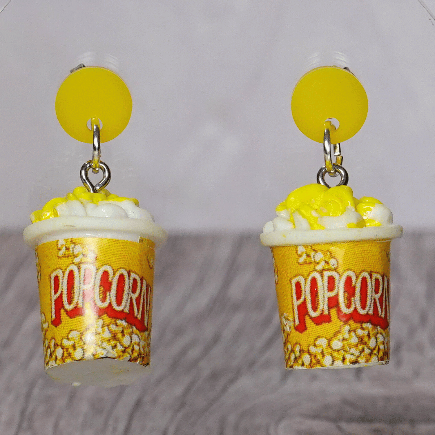 Yellow popcorn bucket shaped dangle earrings filled with popcorn and yellow stud tops