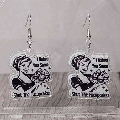 Retro style novelty dangle earrings with a vintage woman holding cupcakes and the phrase “I baked you some shut the fucupcakes”