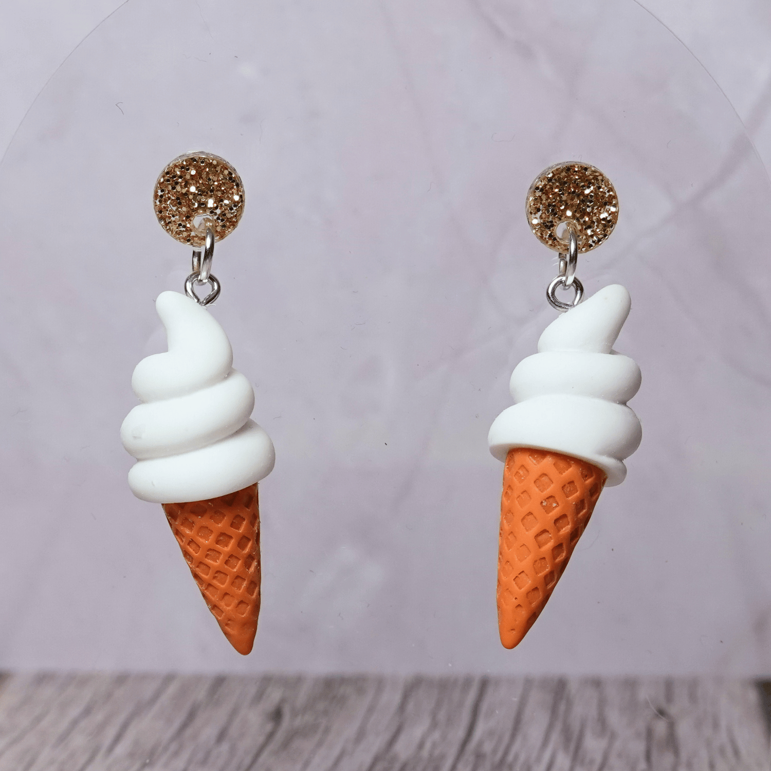 Cute dangle earrings shaped like soft serve vanilla ice cream in waffle cones.