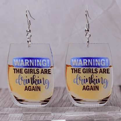 Wine glass dangle earrings with text “warning the girls are drinking again”