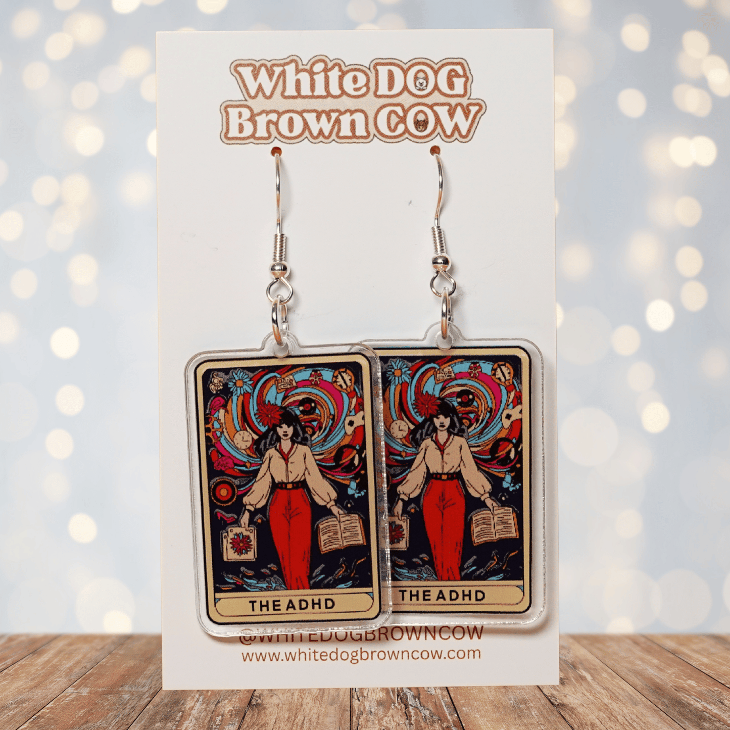 Acrylic dangle earrings featuring a colorful tarot-style card labeled “The ADHD” with a woman surrounded by swirling patterns and books.