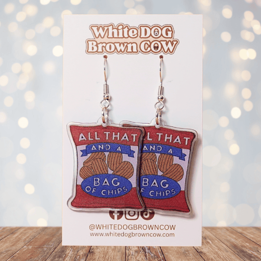 Funny acrylic dangle earrings shaped like a red chip bag that reads “All That and a Bag of Chips,” featuring illustrated potato chips and retro lettering.