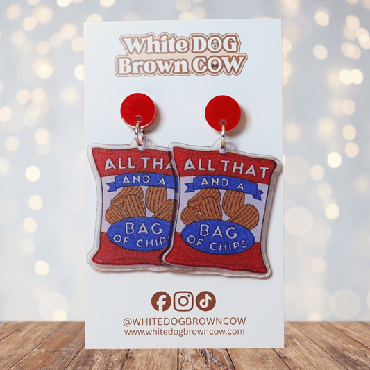 Funny acrylic dangle earrings shaped like a red chip bag that reads “All That and a Bag of Chips,” featuring illustrated potato chips and retro lettering.