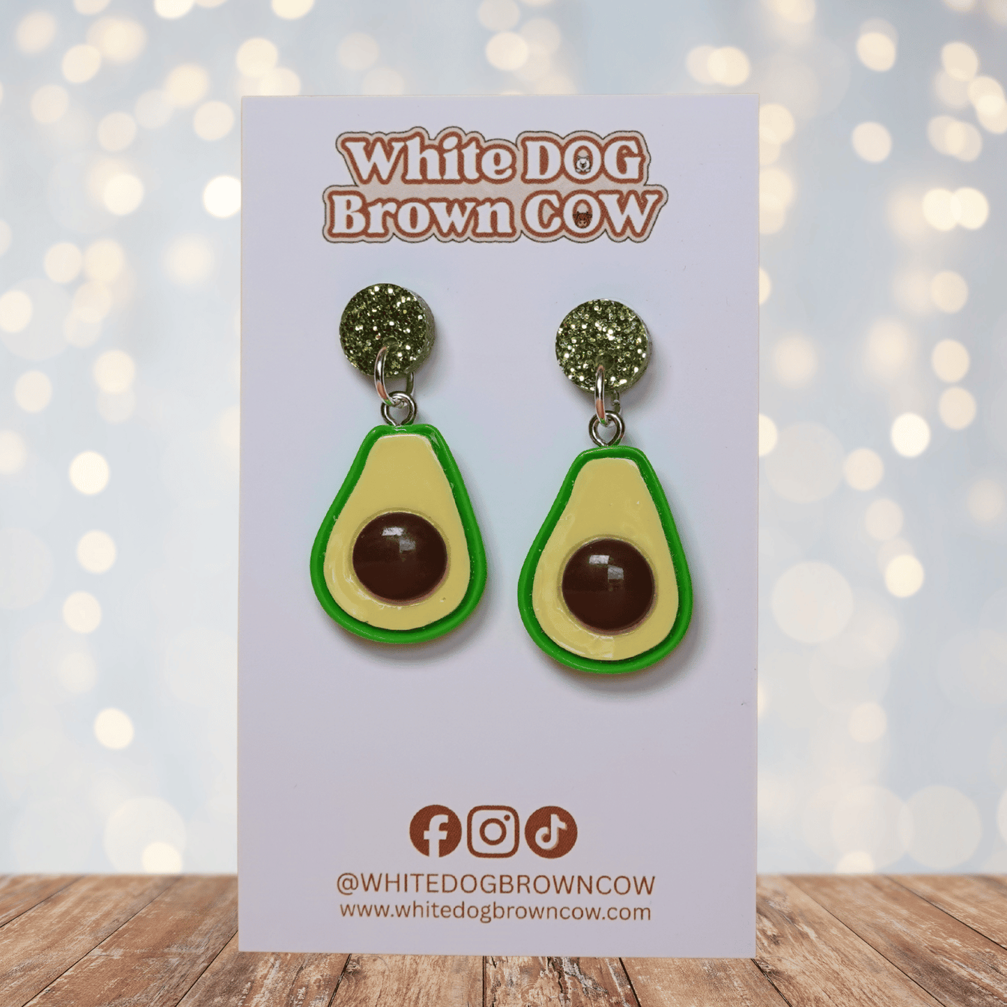 Avocado shaped dangle earrings with green outline, pale yellow center and raised brown pit 