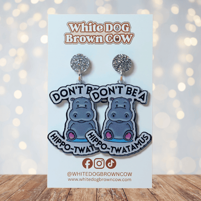 Novelty dangle earrings with a cute cartoon hippo and the phrase “Don’t be a hippo-twatamus”