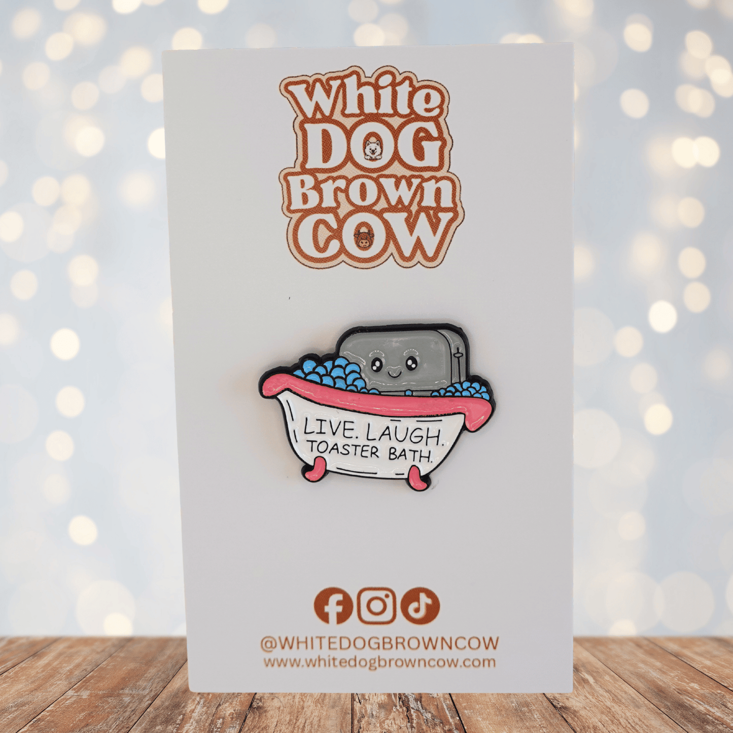 Funny dark humor enamel pin of smiling toaster in a bubble bath with text “live laugh toaster bath,” sarcastic novelty meme pin