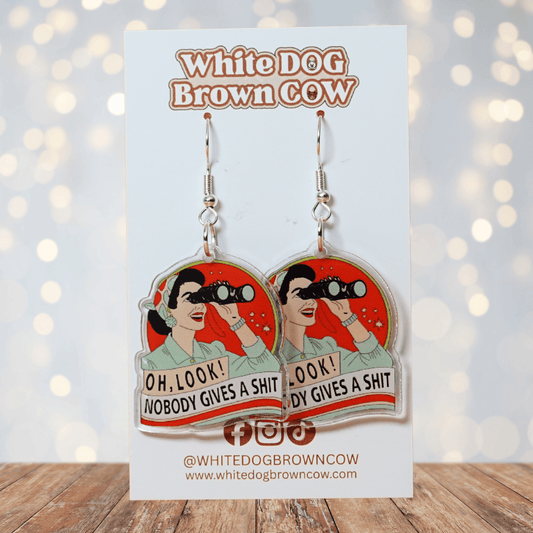 Retro style novelty dangle earrings showing a woman with binoculars and the phrase “Oh look nobody gives a sh*t”